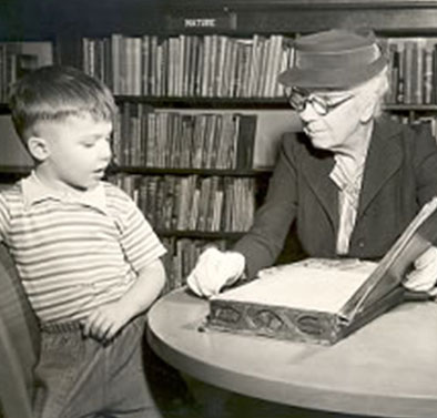 May Quigley and Child looking at book