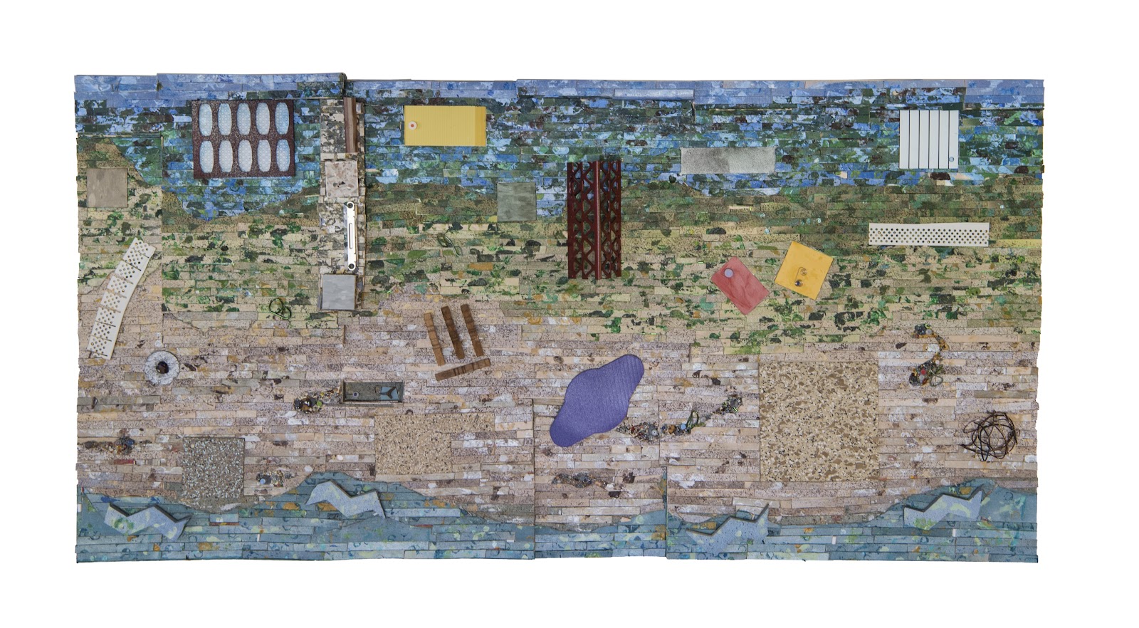 A rectangular mixed-media sculpture resembling an aerial landscape, transitioning from deep blue at the bottom to sandy beige in the center and greenish-blue at the top. Various materials form textured surfaces, with scattered geometric panels in yellow, red, and gray, along with abstract shapes including a purple irregular form, lattice-like structures, and coiled wire.