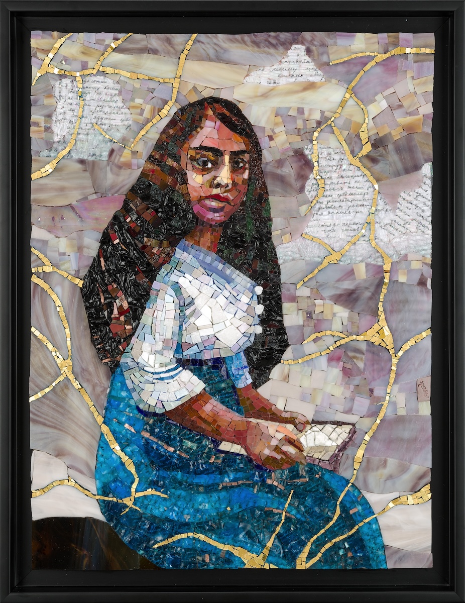 Framed mosaic artwork depicting a seated woman with long dark hair in profile, wearing a blue dress and a white shawl, holding a small object in their hands. The background is made of pale lavender and beige tiles with curving gold lines and faint handwritten text fragments embedded throughout.
