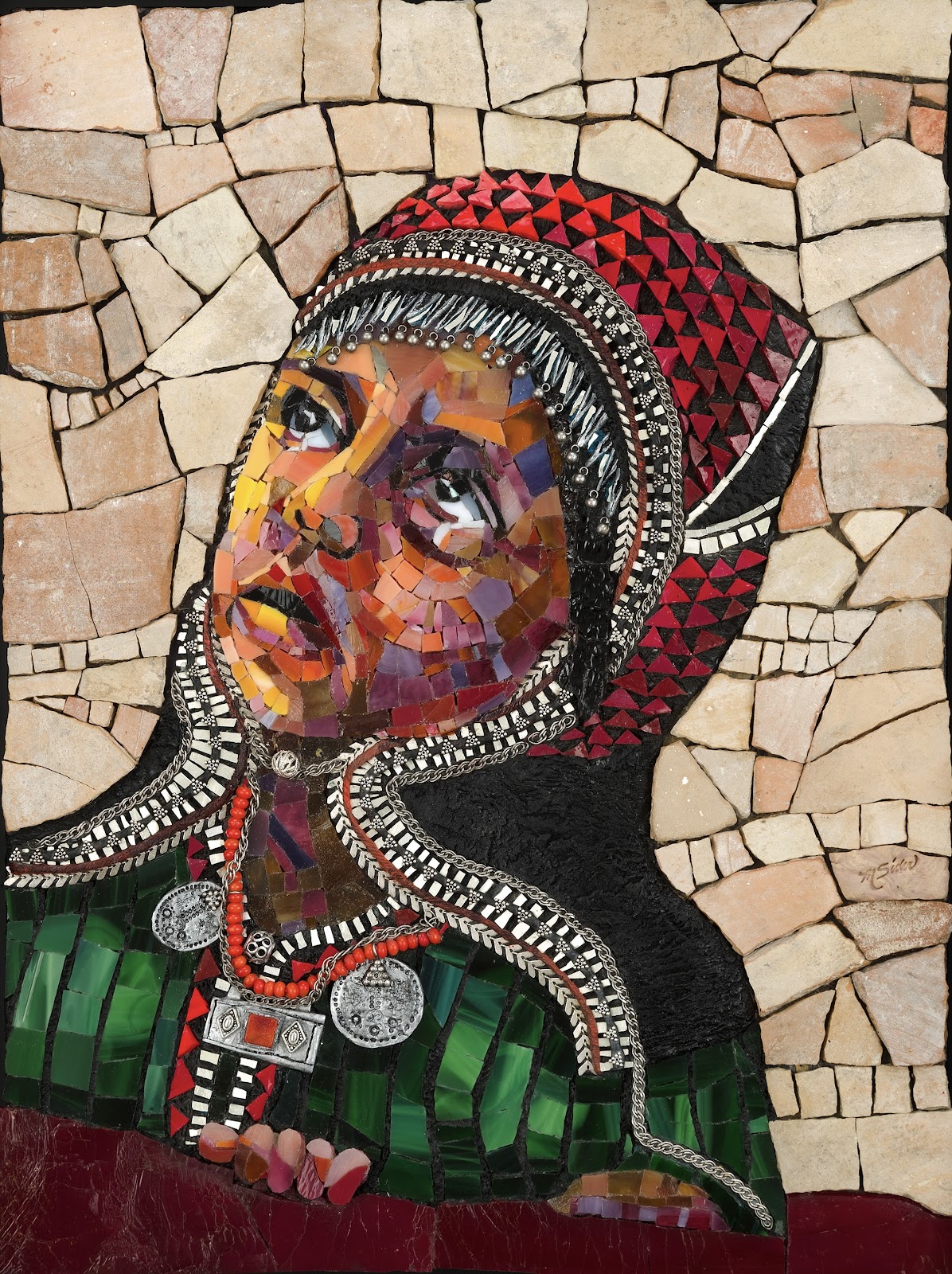 Glass mosaic portrait of a person with the face obscured by a rectangular blur, shown in profile wearing a red patterned headscarf and a black garment with bold black-and-white trim. Red beaded necklaces with silver medallions and a pendant hang over a green, tiled-looking garment. The background is made of irregular tan stone-like mosaic pieces, with a dark red band along the bottom.